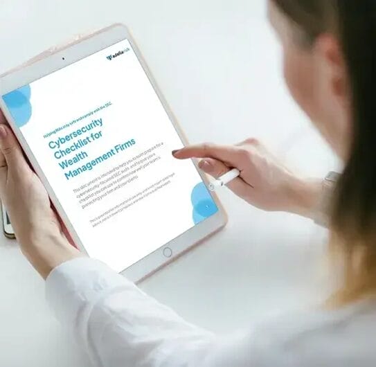 Professional reviewing cybersecurity checklist for wealth management firms on tablet, focusing on compliance and security best practices for RIAs.